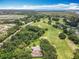 Beautiful aerial view showcasing a home near a golf course and a road along a scenic lake at 8640 Firestone Cir, Clermont, FL 34711
