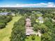 Stunning aerial view of homes bordering a lush golf course and scenic lake at 8640 Firestone Cir, Clermont, FL 34711