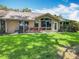 Charming home with a spacious backyard featuring a tiled patio with outdoor seating at 8640 Firestone Cir, Clermont, FL 34711