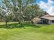 Expansive backyard featuring mature trees, well-kept lawn, and screened-in porch at 8640 Firestone Cir, Clermont, FL 34711