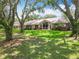 Beautiful backyard featuring a lush lawn, mature trees, and screened-in lanai at 8640 Firestone Cir, Clermont, FL 34711