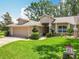Charming single-Gathering home featuring a well-manicured lawn and a two-car garage at 8640 Firestone Cir, Clermont, FL 34711
