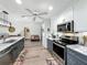 Modern kitchen with stainless steel appliances, stone countertops, and gray lower cabinets at 8640 Firestone Cir, Clermont, FL 34711