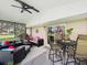 Covered outdoor patio featuring stylish furniture, ceiling fan and sliding glass doors at 8640 Firestone Cir, Clermont, FL 34711