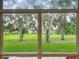 Scenic view from the window overlooking a lush green lawn with mature trees at 8640 Firestone Cir, Clermont, FL 34711