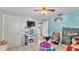 Bright bedroom featuring a ceiling fan, tile flooring, and kid-friendly decor and furnishings at 1019 Milner E Dr, Lakeland, FL 33810