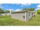Side view of house featuring gray siding and a well-maintained lawn at 1019 Milner E Dr, Lakeland, FL 33810