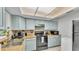 Traditional kitchen features light blue cabinetry, neutral countertops, and black appliances at 1019 Milner E Dr, Lakeland, FL 33810