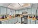Traditional kitchen features light blue cabinetry, neutral countertops, and appliances at 1019 Milner E Dr, Lakeland, FL 33810
