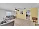 Open living room with yellow brick accent wall, tile flooring, and gray sofas at 1019 Milner E Dr, Lakeland, FL 33810