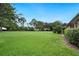 Lush, green backyard with mature trees offering a private and serene outdoor space at 105 Woden Way, Winter Haven, FL 33884