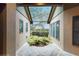 Enclosed courtyard features a tiled floor, garden area, and screened overhead protection at 105 Woden Way, Winter Haven, FL 33884
