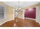 Dining room with hardwood flooring, white trim, and sophisticated chandelier lighting at 105 Woden Way, Winter Haven, FL 33884