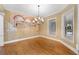 Elegant dining room with hardwood floors, decorative mural, and a stylish chandelier at 105 Woden Way, Winter Haven, FL 33884