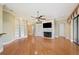 Open-concept living room with stone fireplace, built-in shelving, and hardwood floors at 105 Woden Way, Winter Haven, FL 33884