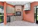 Outdoor kitchen featuring brick fireplace and countertop seating area at 105 Woden Way, Winter Haven, FL 33884