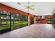 Spacious screened patio featuring brick flooring, fan, fireplace, and views of the landscaped backyard at 105 Woden Way, Winter Haven, FL 33884