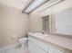 Well-lit bathroom featuring a shower, toilet, vanity, mirror, and tiled floors, providing a clean and functional space at 1102 Eagle Pond Dr # 1102, Winter Haven, FL 33884