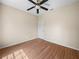 Cozy bedroom featuring wood-look floors, a ceiling fan, and a door at 1102 Eagle Pond Dr # 1102, Winter Haven, FL 33884