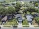 Aerial view of home in a residential neighborhood with mature trees and a nearby lake at 124 Eagle Point Blvd, Auburndale, FL 33823