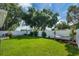 A spacious backyard with a green lawn, white fence, and a comfortable hammock for relaxation at 124 Eagle Point Blvd, Auburndale, FL 33823