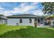 Green backyard with a cozy fire pit, patio, and access to the house at 124 Eagle Point Blvd, Auburndale, FL 33823