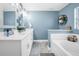 Bright bathroom features a soaking tub and double vanity with modern finishes at 124 Eagle Point Blvd, Auburndale, FL 33823