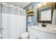 Bright bathroom with white cabinets, decorative sign, and shower with curtain at 124 Eagle Point Blvd, Auburndale, FL 33823