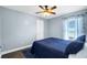Relaxing bedroom features a blue accent wall, ceiling fan, and a cozy blue quilt at 124 Eagle Point Blvd, Auburndale, FL 33823