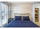 Cozy bedroom with a modern bed frame, white accent wall, and blue quilted bedding at 124 Eagle Point Blvd, Auburndale, FL 33823