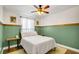 Cozy bedroom with a green accent wall, wood trim, and a white patterned comforter at 124 Eagle Point Blvd, Auburndale, FL 33823