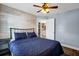 Bright bedroom with a stylish white accent wall, ceiling fan, and blue quilted bedding at 124 Eagle Point Blvd, Auburndale, FL 33823