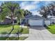 Inviting one-story home with a landscaped front yard, a two-car garage, and covered entryway at 124 Eagle Point Blvd, Auburndale, FL 33823
