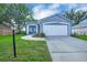 Charming one-story home with a well-maintained lawn, a two-car garage, and inviting front entrance at 124 Eagle Point Blvd, Auburndale, FL 33823