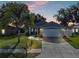 Picturesque home at dusk with a manicured lawn, a two-car garage, and welcoming curb appeal at 124 Eagle Point Blvd, Auburndale, FL 33823