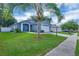 Charming single-Gathering home with a lush green lawn, a two-car garage, and mature palm trees at 124 Eagle Point Blvd, Auburndale, FL 33823