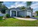 Inviting single-story home with a blue door, manicured lawn, and a charming front yard landscape at 124 Eagle Point Blvd, Auburndale, FL 33823