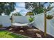 Close up of hammock, with landscaping, mulch and stone accents, and wood fence at 124 Eagle Point Blvd, Auburndale, FL 33823