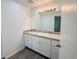 Bathroom with white cabinets, granite countertops, modern fixtures and gray wood-look flooring at 1476 Avenue F Ne, Winter Haven, FL 33881