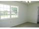 This bedroom has a double window and neutral color carpet and walls at 1476 Avenue F Ne, Winter Haven, FL 33881