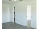 Well-lit bedroom featuring gray wood-look floors and white doors at 1476 Avenue F Ne, Winter Haven, FL 33881