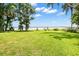 Expansive backyard overlooking a serene lake, framed by lush trees, creating a picturesque scene at 15 Edwards Shrs, Haines City, FL 33844