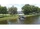 Scenic view of private dock featuring a covered boat lift amidst tranquil water and lush shoreline at 15 Edwards Shrs, Haines City, FL 33844