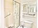 Clean bathroom featuring a walk-in shower with grab bars, toilet, and mirrored medicine cabinet at 1776 6Th Street Nw # 709, Winter Haven, FL 33881