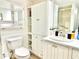 Bright bathroom featuring a sink, toilet, shower, mirror, and lots of built-in storage at 1776 6Th Street Nw # 709, Winter Haven, FL 33881