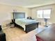 Cozy bedroom with a bed, large headboard, chair, and scenic view at 1776 6Th Street Nw # 709, Winter Haven, FL 33881