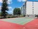 Outdoor tennis court with net on sunny day with the community condominium in the background at 1776 6Th Street Nw # 709, Winter Haven, FL 33881