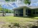 Well-maintained backyard featuring a screened patio, playset, and lush lawn at 1790 Turtle Rock Dr, Lakeland, FL 33803