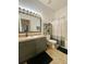 Bathroom features a single vanity, toilet, shower with curtain, and storage shelves at 1790 Turtle Rock Dr, Lakeland, FL 33803