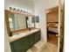 Bathroom features a large mirror, double vanity with olive green cabinets, and beige countertops at 1790 Turtle Rock Dr, Lakeland, FL 33803
